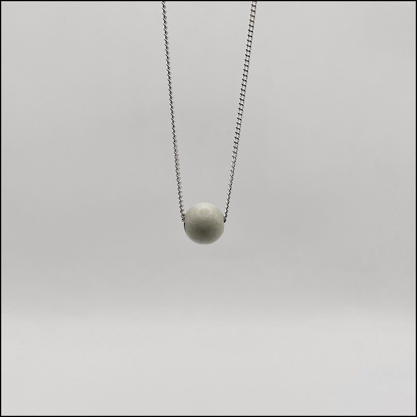 Necklace with a round pendant on a light gray background