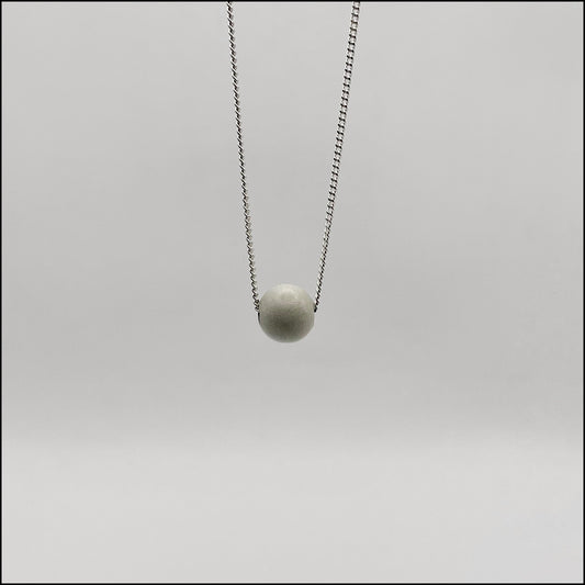 Necklace with a round pendant on a light gray background